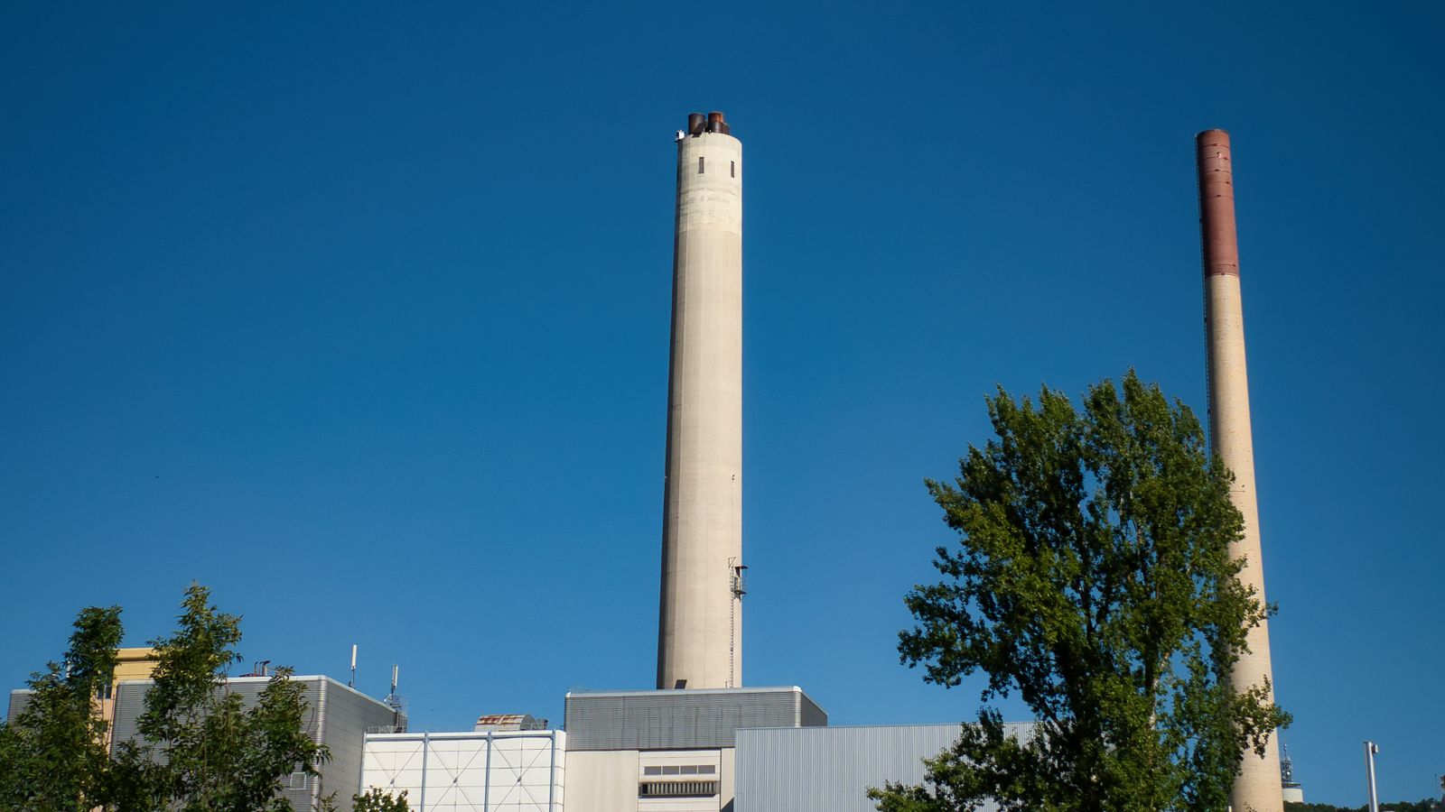 Cheminées d'une centrale électrique se détachant sur un ciel bleu.