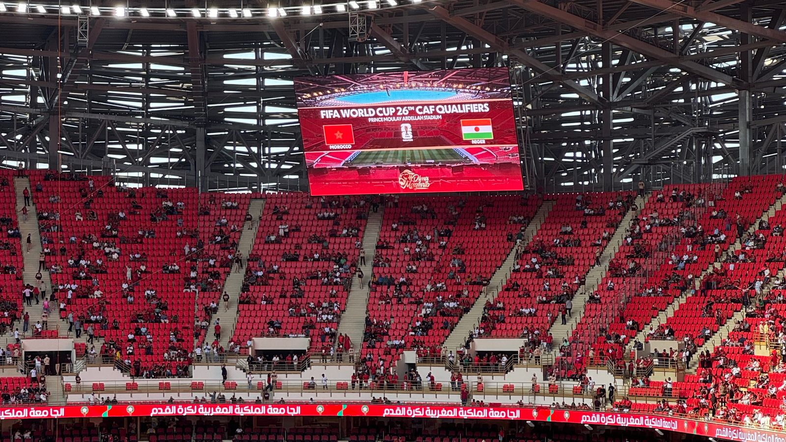 Stade rempli lors d'un match de qualification à la Coupe du monde, écran géant affichant l'inscription FIFA World Cup.