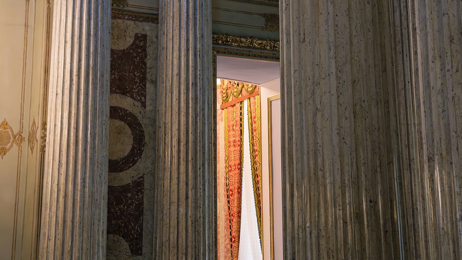 Colonnes architecturales sculptées dans un intérieur historique orné, évoquant la solennité des institutions.