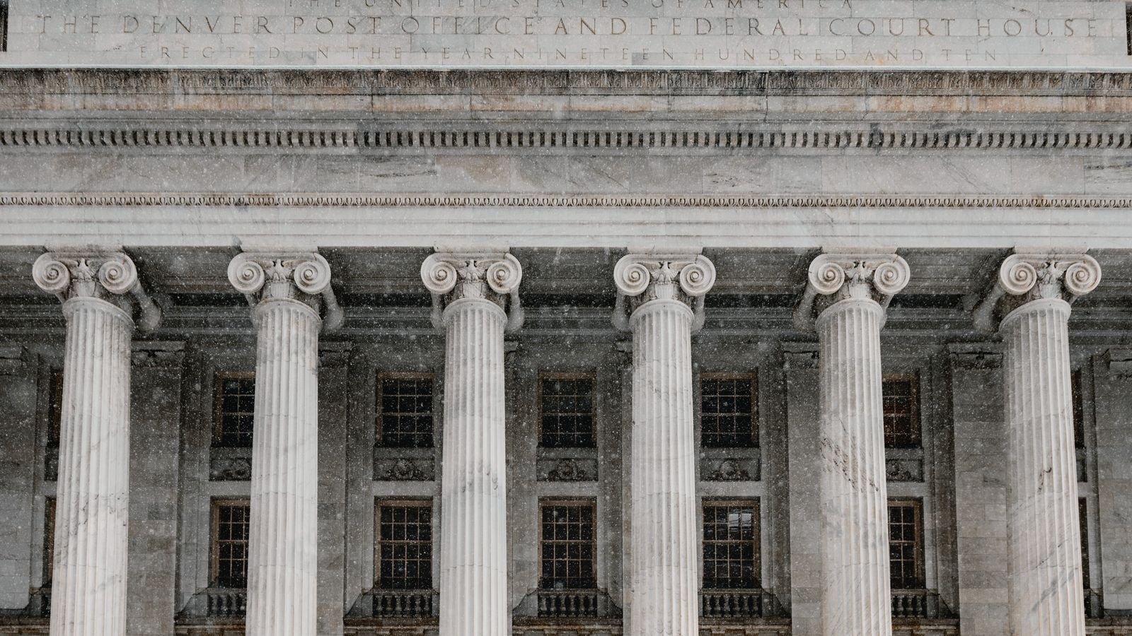 Colonnade d'un palais de justice fédéral américain, façade en pierre.